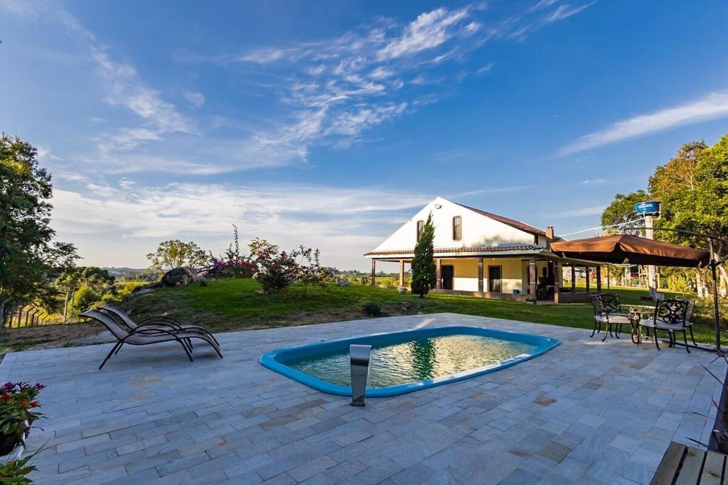 Piscina com espreguiçadeiras e vista para o jardim